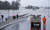 An emergency vehicle blocks access to the flooded Windsor Bridge on the outskirts of Sydney, Australia, Monday, July 4, 2022. 