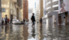 People walk through flood water caused by heavy rains, in Dubai, United Arab Emirates, April 17, 2024. (Reuters)