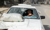 A displaced Palestinian man drives a car damaged during Israel's military offensive as he flees Rafah, in southern Gaza.