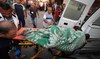 Paramedics transport a body at the Al-Aqsa Martyrs Hospital in Deir Al-Balah following Israeli bombardment on May 23, 2024.