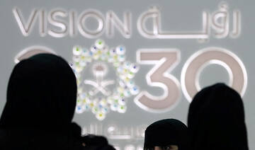 Saudi women stand next to the Saudi pavilion at the Gitex 2018 exhibition at the Dubai World Trade Center in Dubai. (AFP)