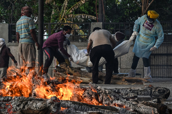 In this photograph taken on May 12, 2021, relatives carry the body of person who died due to the Covid-19 coronavirus victim at a crematorium in New Delhi. (AFP / Arun Sankar)