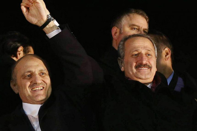 In this Dec 24, 2013 photo, Turkey's Environment Minister Erdogan Bayraktar (left) and Economy Minister Zafer Caglayan greet supporters at the Esenboga Airport in Ankara. (AFP files)