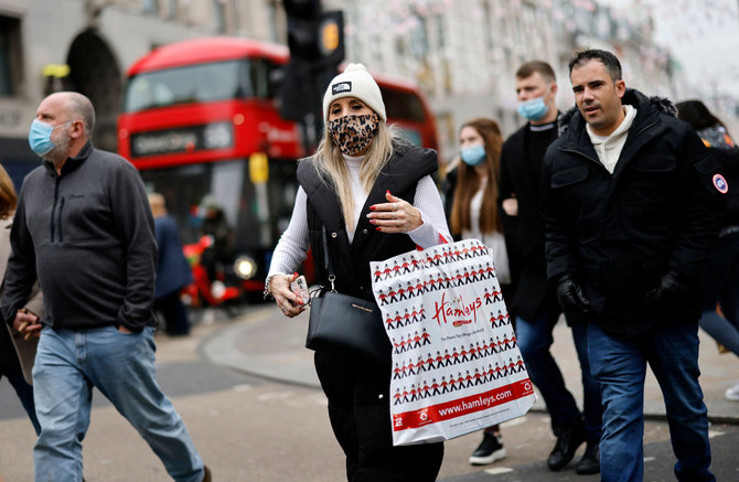 Some members of the public have started wearing face masks as they walk on Oxford Street in London on Dec. 21, 2021. (Tolga Akmen / AFP)