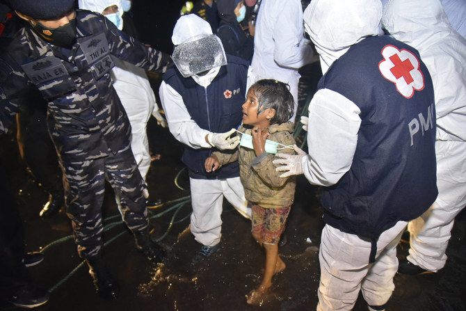 Medical workers help a Rohingya young girl upon arrival at Krueng Geukueh Port in North Aceh, Indonesia, on Dec. 31, 2021. Rohingya Muslims have fokr the p[ast years been fleeing persecution and poverty from Myanmar. (AP Photo/Rahmat Mirza)