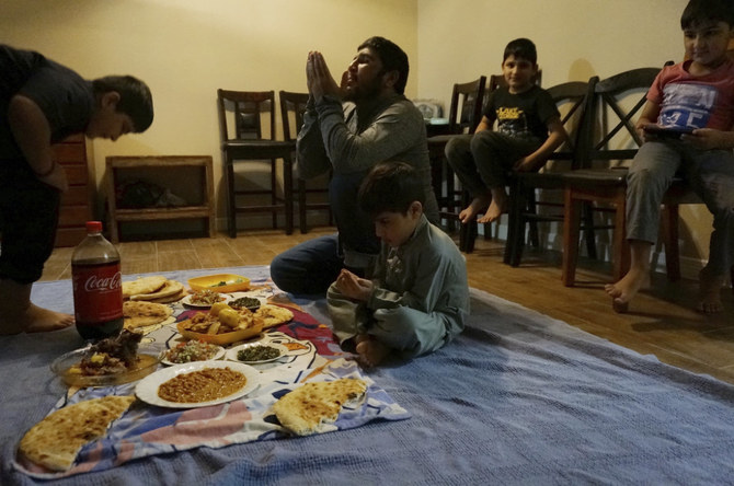 An Afghan family prepares to break the Ramadan fast at their new apartment in El Paso, Texas, on Sunday, April 3, 2022. They are the luckier ones who were evacuated when the Taliban regained power last summer in Afghanistan. (AP Photo/Giovanna Dell'Orto)