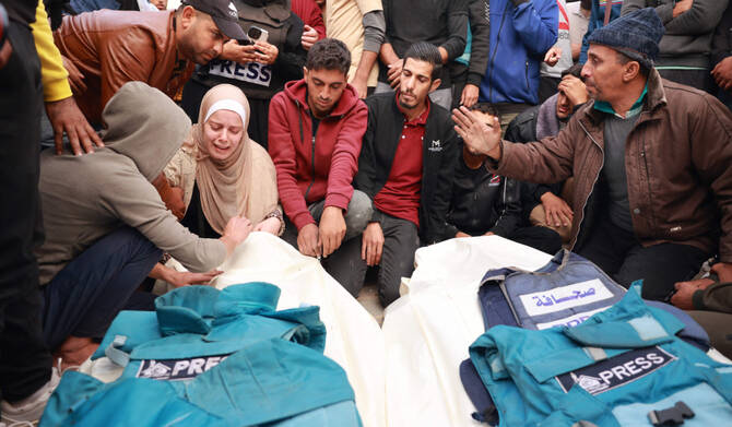 Relatives and colleagues of two Palestinian journalists killed in an Israeli strike, mourn over their bodies in Gaza. (AFP)