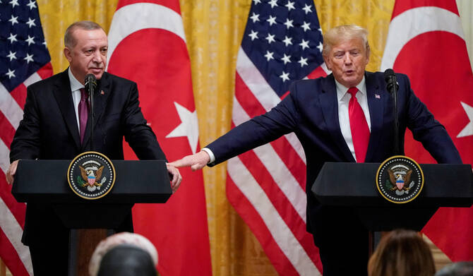 U.S. President Donald Trump reaches to Turkey's President Tayyip Erdogan during a joint news conference in Washington. (REUTERS)