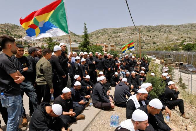 Druze men demonstrate in solidarity with the Syrian Druze community near the border barrier in Majdal Shams (File/AFP)
